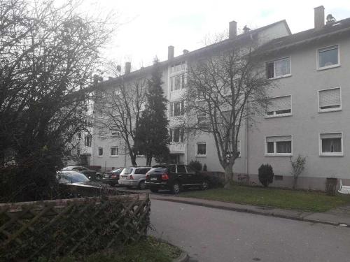 a large white building with cars parked in a parking lot at City Apartment in Eppelheim in Eppelheim