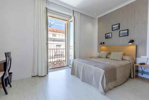 a bedroom with a bed and a large window at Hotel Europa in Madrid