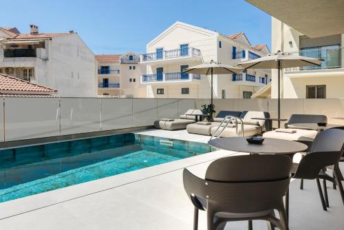 a patio with a table and chairs and a swimming pool at G Boutique Hotel Kefalonia in Argostoli