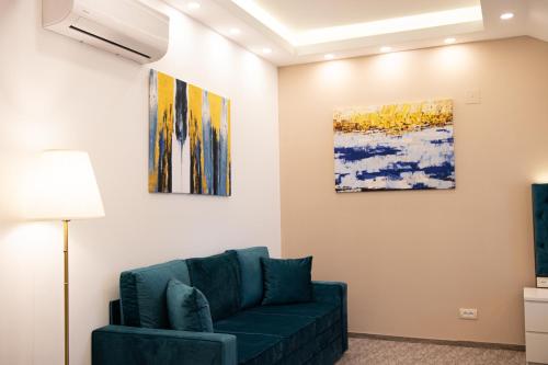 a living room with a couch and two paintings at Luxury Rooms Skadarlija in Belgrade