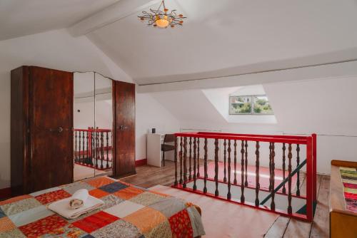 a bedroom with a bed with a red rail at Casa do Mestrinho 2 in Avintes