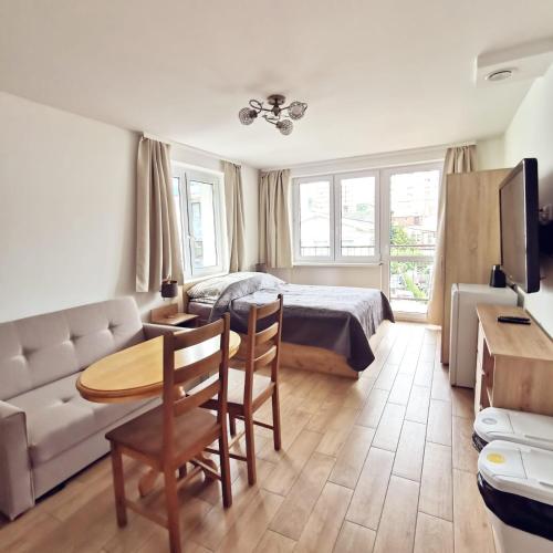 a bedroom with a bed and a table and a couch at Villa Krysia 50 m do morza in Międzyzdroje