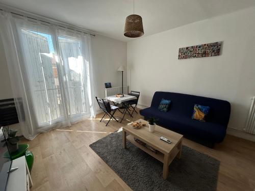 un salon avec un canapé bleu et une table dans l'établissement La fontaine, à Arles