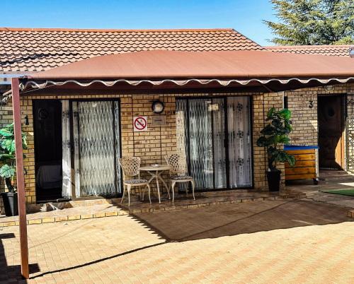 a small brick house with a table and chairs at Siyaya Sbosh BnB in Reitz