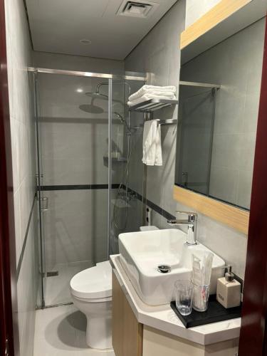 a bathroom with a sink and a toilet and a mirror at Lee Apartment & Hotel in Hai Phong