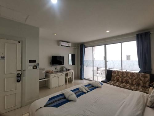 a bedroom with a large bed with a large window at Phuket Racha Kata Homestay in Kata Beach