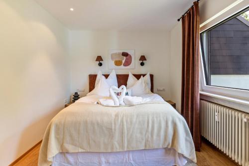 a bedroom with a bed with white sheets and a window at Ferienwohnung Schluchsee Idylle in Schluchsee