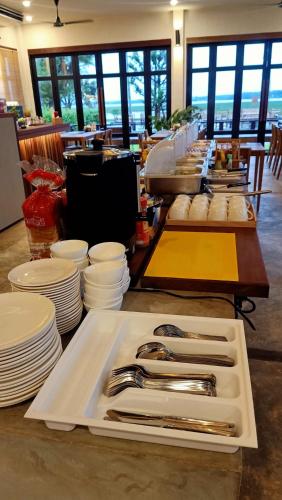 einen Tisch mit Tellern und Küchenutensilien auf dem Tisch in der Unterkunft Zenery Lake Resort in Ban Don Klang
