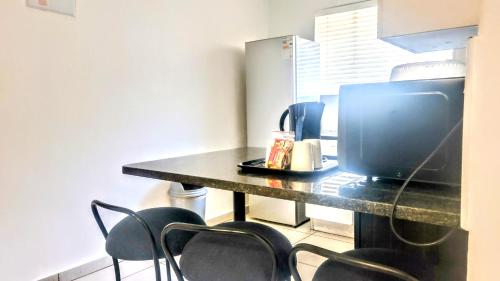 a kitchen with a table with chairs and a television at Palmar Hotel in Johannesburg