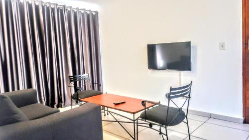 a living room with a couch and a table and a tv at Palmar Hotel in Johannesburg