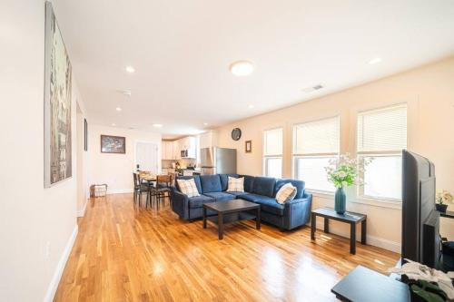 a living room with a blue couch and a table at 30-3 - 3BR Boston - Cozy Apt near Franklin Park Zoo in Boston