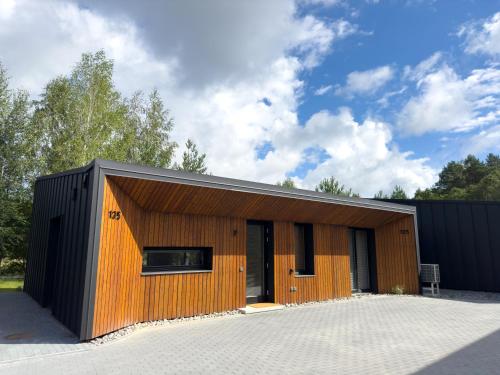 a large wooden building with a black roof at IVIS House Lakeside Retreat in Vilnius in Vilnius
