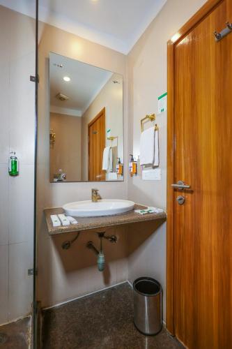 a bathroom with a sink and a large mirror at Le Roi Udaipur in Udaipur