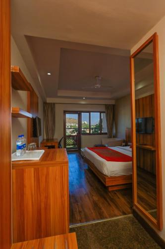 a bedroom with a bed and a bathroom with a sink at Le Roi Udaipur in Udaipur