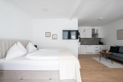 a white bedroom with a bed and a couch at FarawayHomes Studio Fohnsdorf #14 in Fohnsdorf