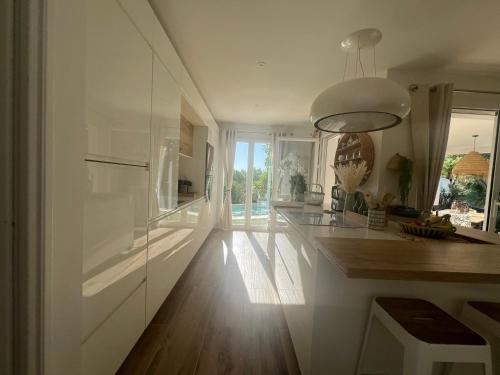 une cuisine avec des placards blancs et un îlot de cuisine dans l'établissement Villa Gessica, à Draguignan