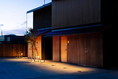 a building with a tree in front of it at Hotel Kitanoya in Miyazu