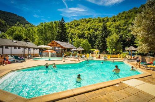 a group of people in a pool at a resort at Camping 3 étoiles - Piscine - eeed0b in Bédouès