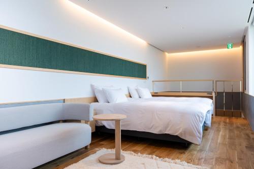 a bedroom with a bed and a couch at Hotel Kitanoya in Miyazu