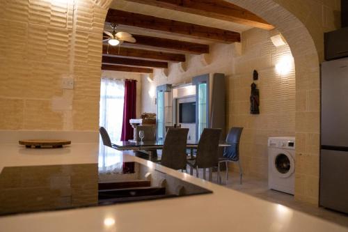 a kitchen and living room with a table and chairs at 4 Bedroom Holiday Farmhouse with Private Pool in Għarb