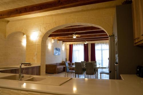 a kitchen and dining room with an archway in a house at 4 Bedroom Holiday Farmhouse with Private Pool in Għarb
