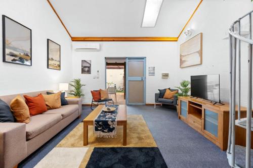 a living room with a couch and a tv at 22 Cottesloe - 1BDR Beach - WITH WIFI in Perth