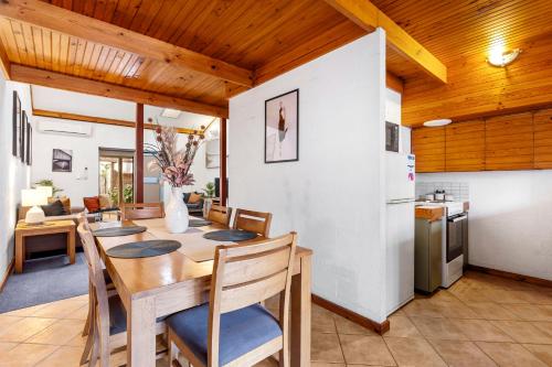 a kitchen and dining room with a wooden ceiling at 22 Cottesloe - 1BDR Beach - WITH WIFI in Perth