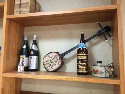 a shelf with bottles of alcohol on it at Joya in Ishigaki Island