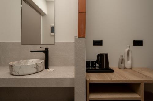 Una cocina con un recipiente sobre una encimera con fregadero. en Solesea Rooms, en Argassi