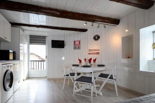 a white dining room with a table and chairs at Chalet Saint Roch Montgenevre in Montgenèvre