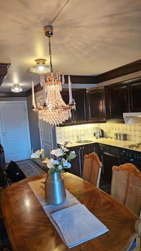 a kitchen with a wooden table and a chandelier at Toppleilighet Dr Holms in Geilo