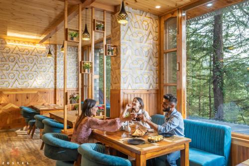 a group of people sitting at a table in a restaurant at Zostel Kotgarh, Narkanda in Kotgarh