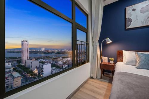a bedroom with a large window with a view of a city at 2BDR Modern Highrise Condo, City & River views, Pool in Da Nang