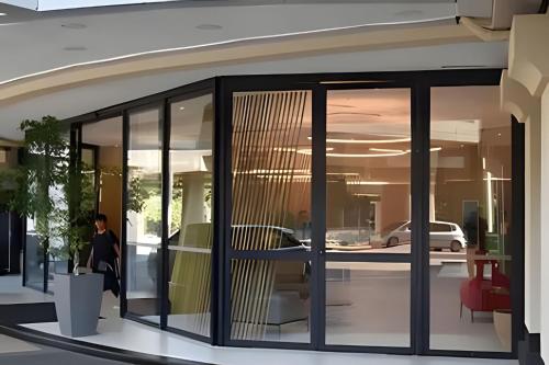 a person walking in a building with glass windows at Airfamily Congonhas in Sao Paulo