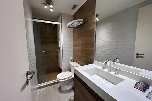 a bathroom with a sink and a toilet and a mirror at Airfamily Congonhas in Sao Paulo