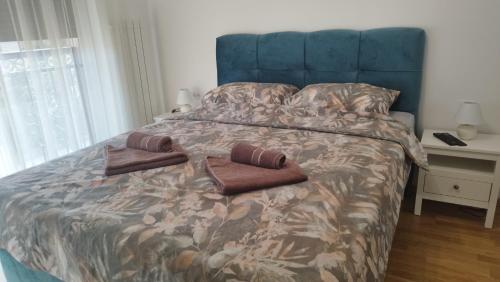 een bed met twee bruine kussens erop bij Apartman NEMANJA in Vrnjačka Banja