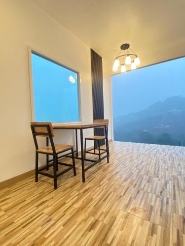 a dining room with a table and chairs and a large window at มิด้าโฮมสเตย์ม่อนแจ่ม in Mon Jam