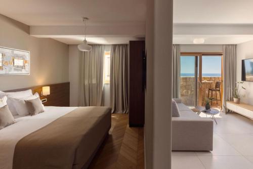 a hotel room with a large bed and a couch at Palace Natali in Dubrovnik