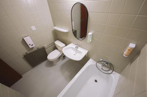 a bathroom with a sink and a toilet and a mirror at ATLAS Hotel Tatry in Vysoké Tatry