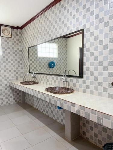 a bathroom with two sinks and a mirror at Vangvieng Sisavang Mountain View Hotel in Vang Vieng