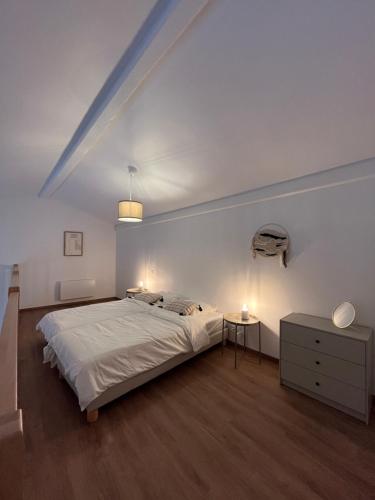 une chambre blanche avec un lit et deux tables de nuit dans l'établissement Résidence Les 4 Quais, à Bordeaux