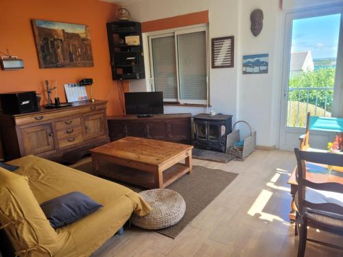 un salon avec un canapé et une table dans l'établissement Maison de vacances à Roscanvel, à Roscanvel