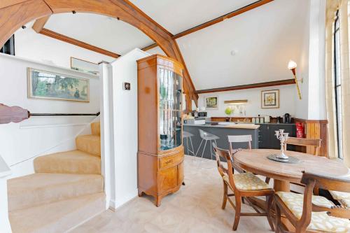 a dining room with a table and a kitchen at The Tracery - Norfolk Cottage Agency in Fakenham