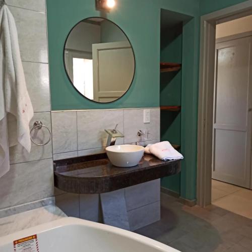 a bathroom with a sink and a mirror at La Estrella in Huerta Grande
