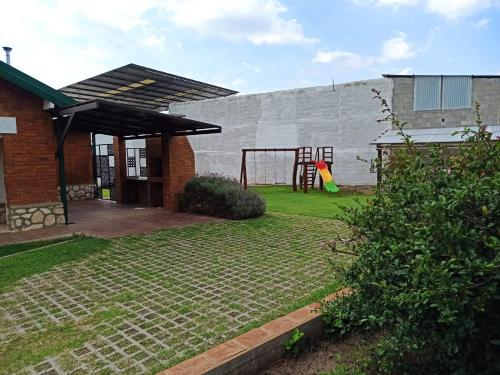 a backyard with a playground and a building at La Estrella in Huerta Grande