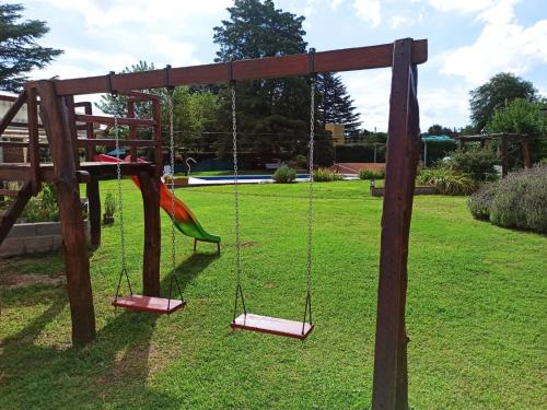 a playground with a swing in a park at La Estrella in Huerta Grande