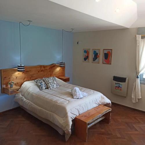 a bedroom with a large bed with a wooden headboard at La Estrella in Huerta Grande