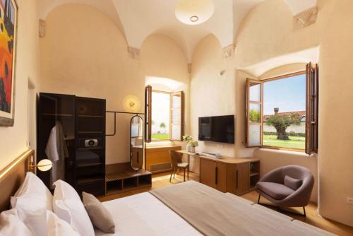 a bedroom with a bed and a desk and a tv at Palace Natali in Dubrovnik
