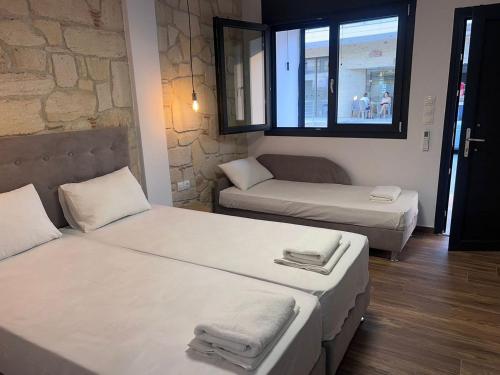 a room with two beds and a couch and a window at Naria Studios in Skala Fourkas