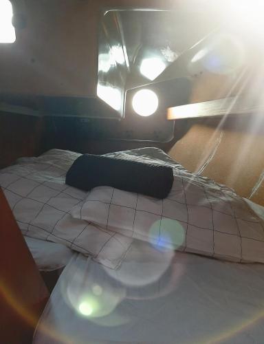 - un lit avec un oreiller et des lumières dans l'établissement Le chant des mouettes - Voilier, à Boulogne-sur-Mer